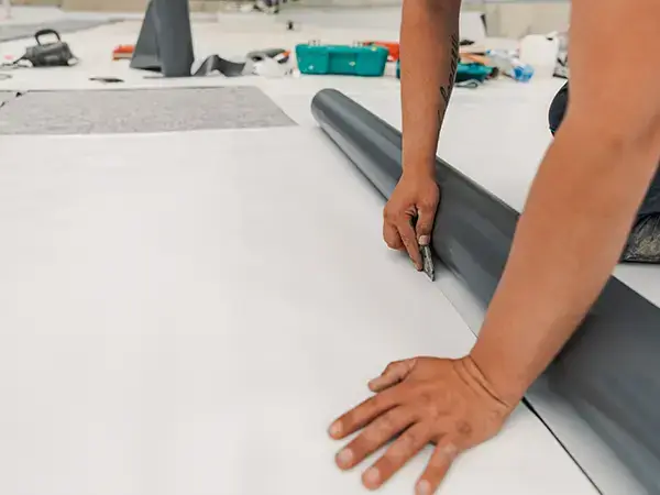 Roofer cutting up a TPO sheet